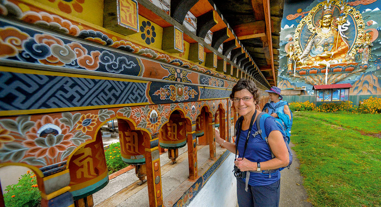 2-slide-bhutan-happy-woman-prayer-wheels-pano - tours - travel